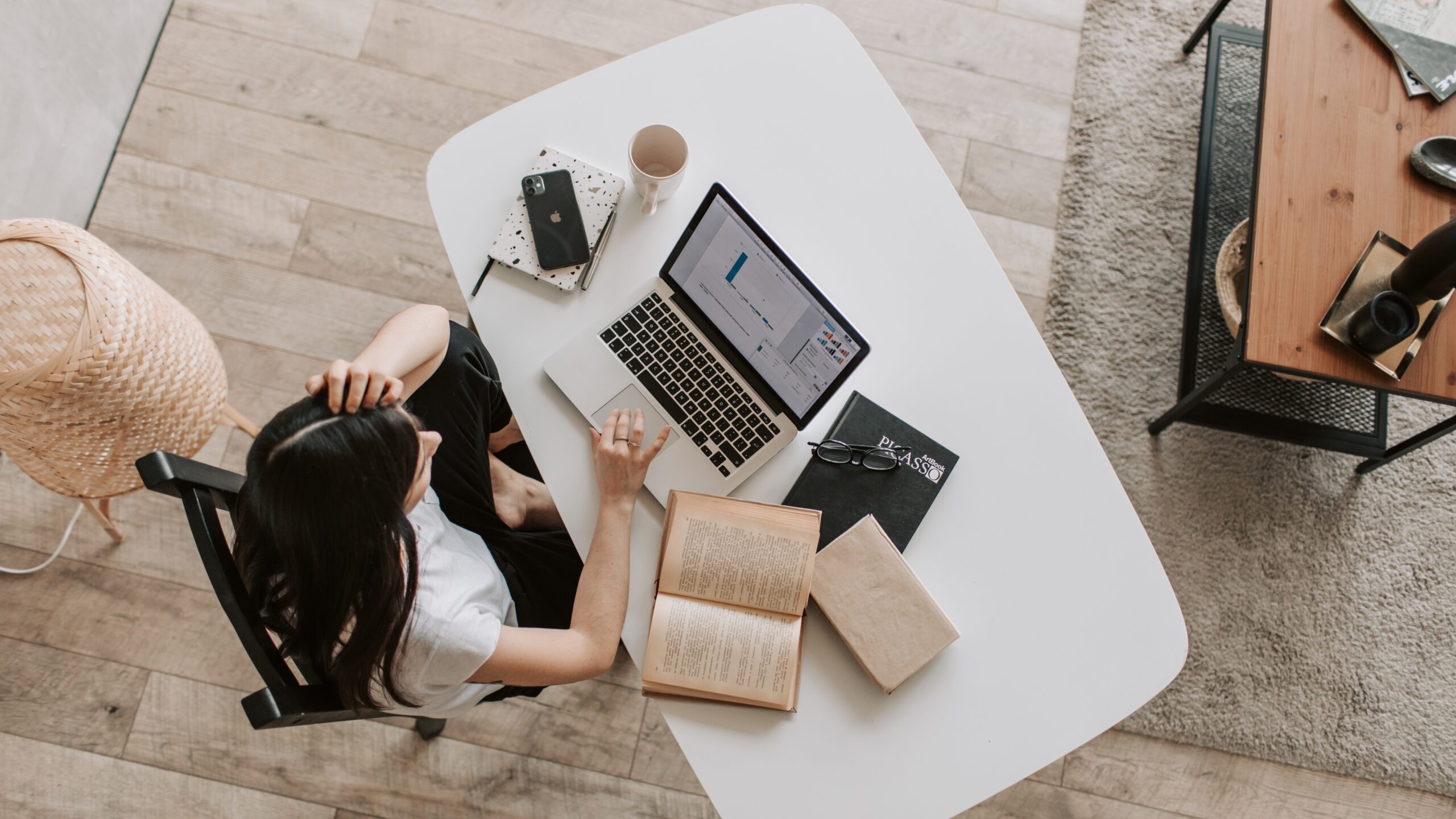 Woman working at a desk on a computer while managing an online business